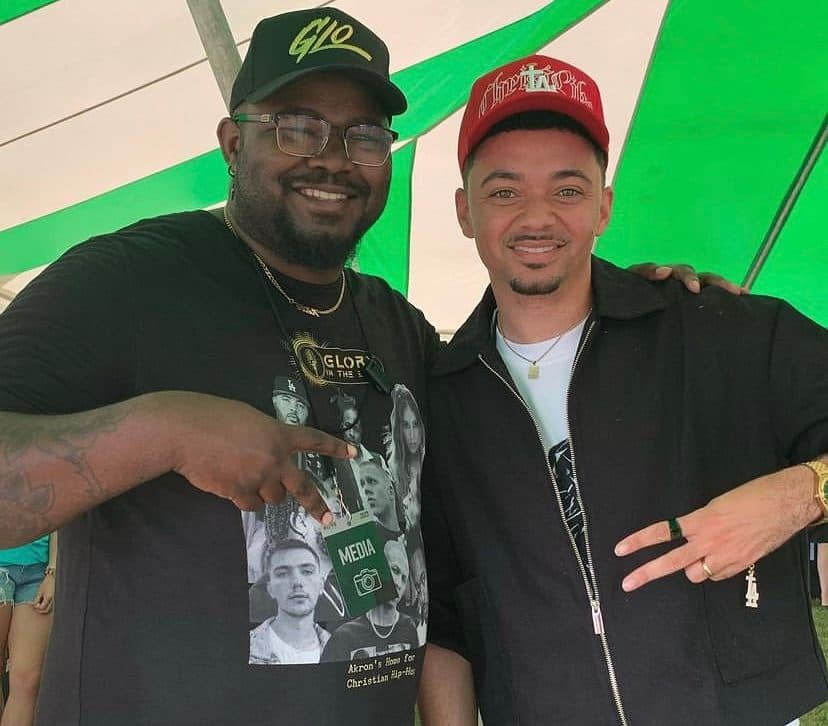 Glory in the Beat, wearing a media pass, with an artist in a festival tent.