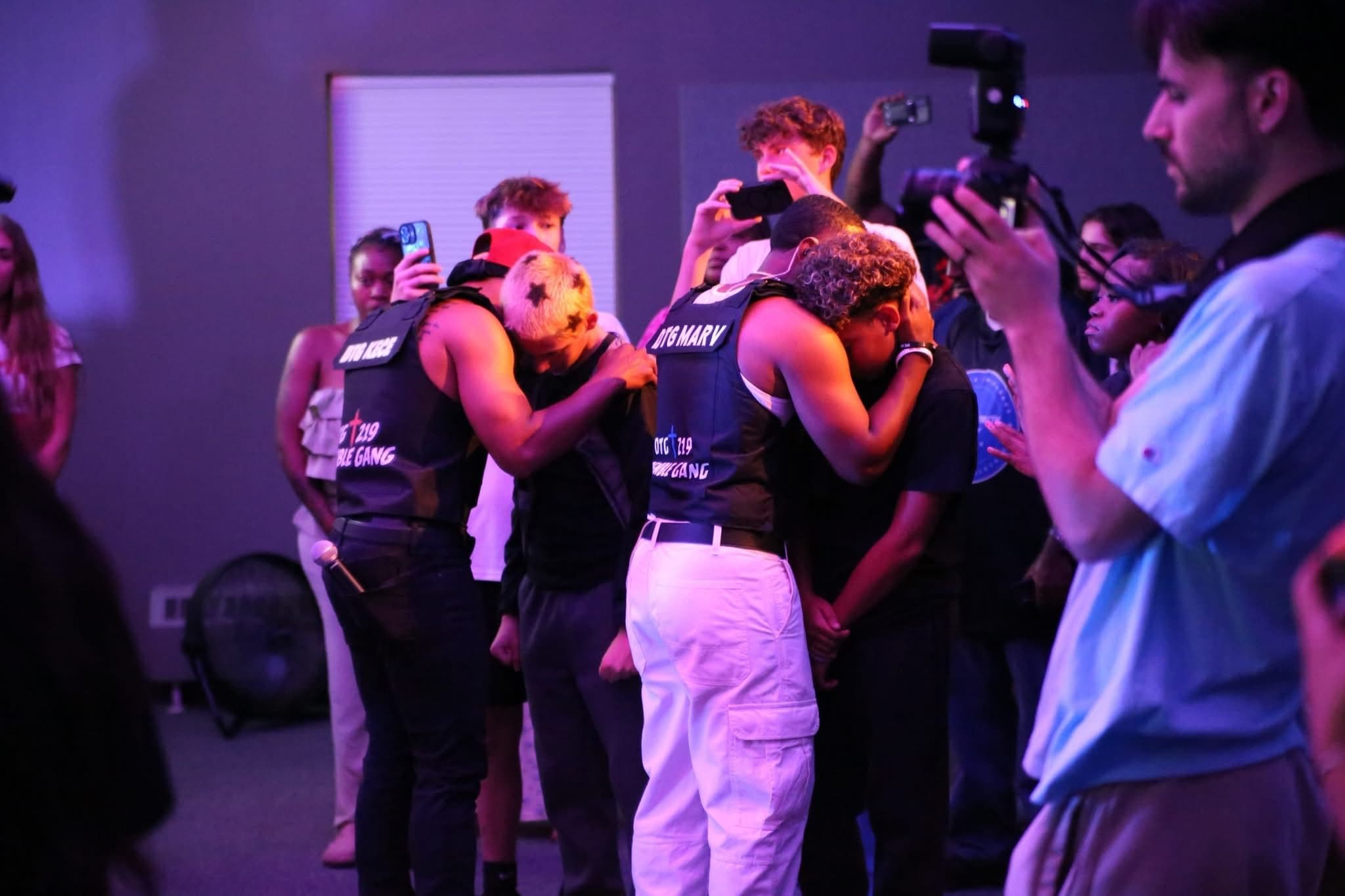Two members of DTG embrace and pray over two young people at Summer Glory.